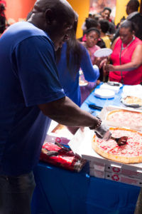 Organizer Keith Freeman serves pizza to the poets and guests. 