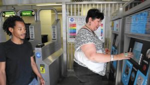 Unity Parenting and Counseling supervisor Anne Holcomb buys single-ride Ventra tickets from a vending machine at a CTA Green Line station Aug. 22, 2016, as James Ivory, left, a client with the social service agency, looks on. (Antonio Perez / Chicago Tribune)