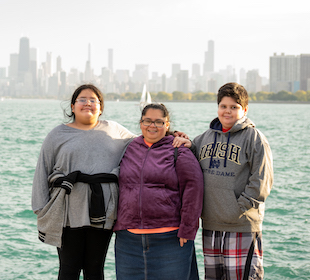 Mom and two children standing in front of Lake Michigan with the Chicago Skyline in the background