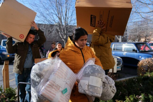 Carolina Gonzalez of Venezuela carries supplies into the Chicago City Life Center Wednesday, Nov. 29, 2023.