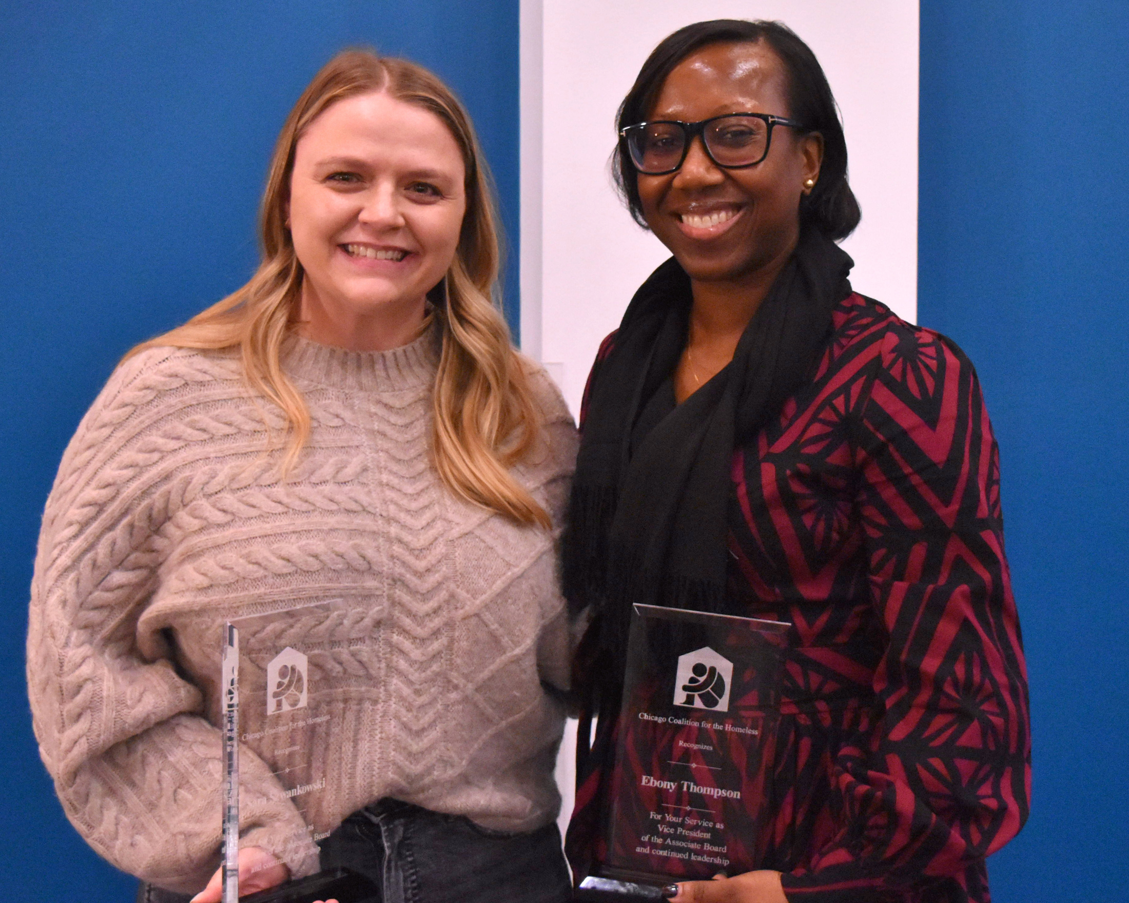 Sara Szwankowski & Ebony Thompson smile while holding their awards.