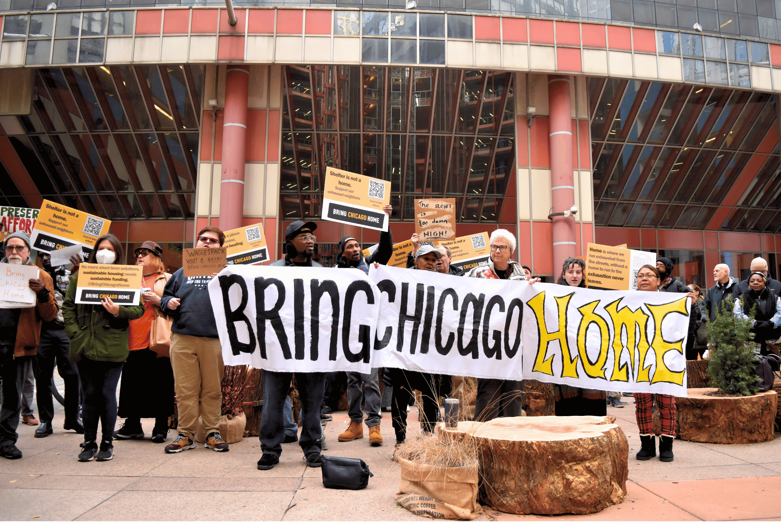 A group of protestors holds a banner reading "Bring Chicago Home"